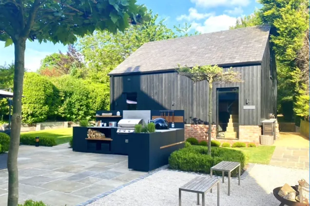 outdoor kitchen in garden on large patio with bull gas grill station and storage cabinets