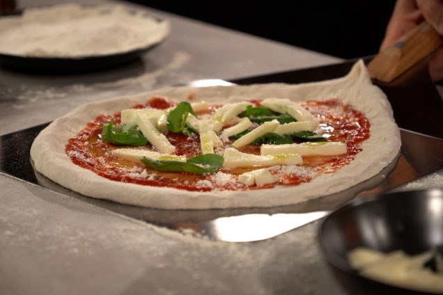 pizza being made in grillo kitchen and being picked up on a pizza peel