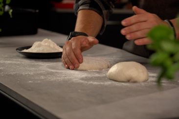 person kneading dough on grillo kitchen worktop