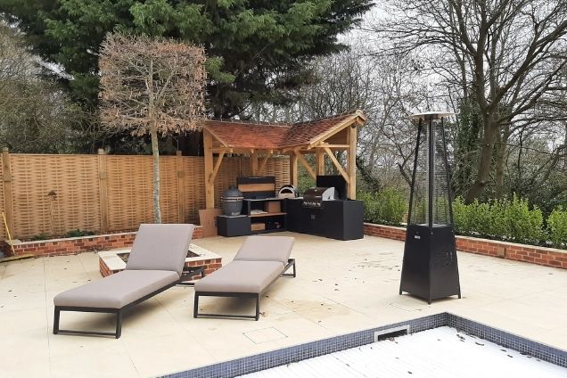 outdoor kitchen under roof next to pool area in Warley, Brentwood