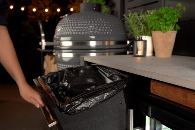 person fitting bin liner to drinks fridge and bin cabinet