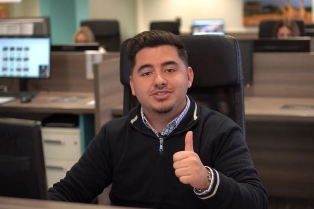 salesman doing thumbs up at desk