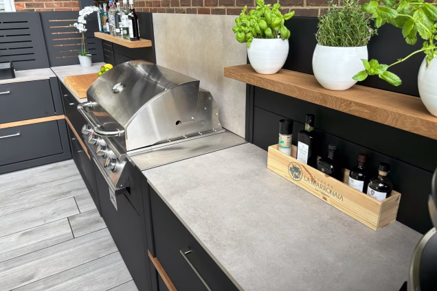outdoor kitchen with storage units and gas bbq