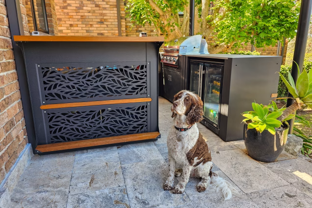 dog sitting next to grillo kitchen with bull gas grill station