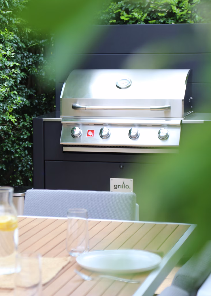 bull gas grill in grillo outdoor kitchen behind table and chairs
