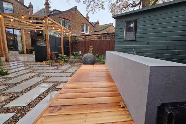 Outdoor kitchen in Dulwich with bench and stone ball feature