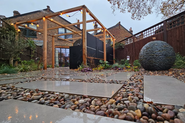 Outdoor kitchen in Dulwich with water feature and stone ball feature
