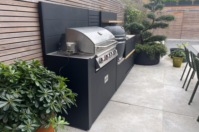 Outdoor kitchen in hammersmith in hard landscaped garden on patio with large outdoor table and chairs