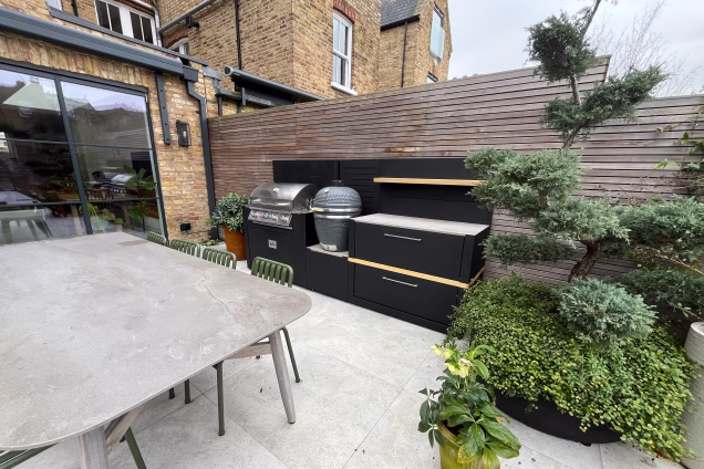 Outdoor kitchen in hammersmith with gas and charcoal bbqs and storage cabinet