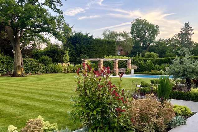 large garden with lawn, outdoor pool, planters and decking