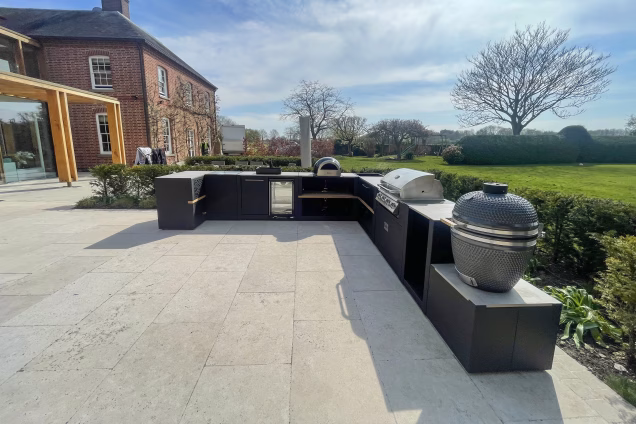 large outdoor kitchen on patio with grillo gusto charcoal bbq, bull bbq and drinks fridge