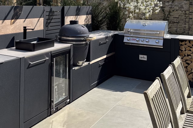 Detail shot of a run of Grillo kitchen in Blackheath, London, featuring a sink and fridge cabinet, a Gusto charcoal barbeque and a Bull gas grill station