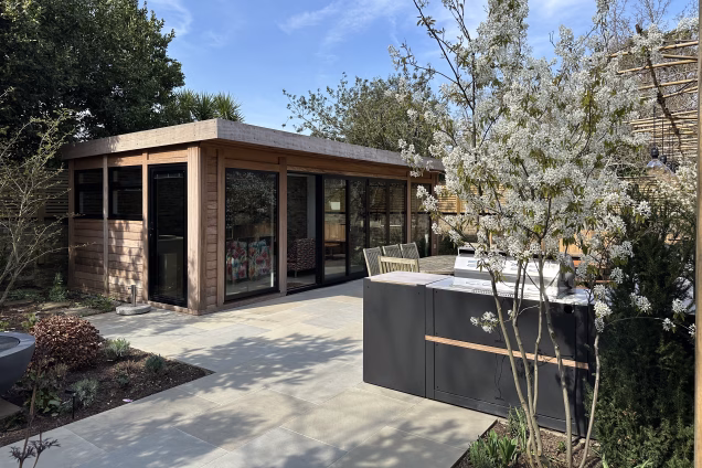A garden building and Grillo outdoor kitchen in Blackheath London, with a small multistem Serviceberry tree in the foreground