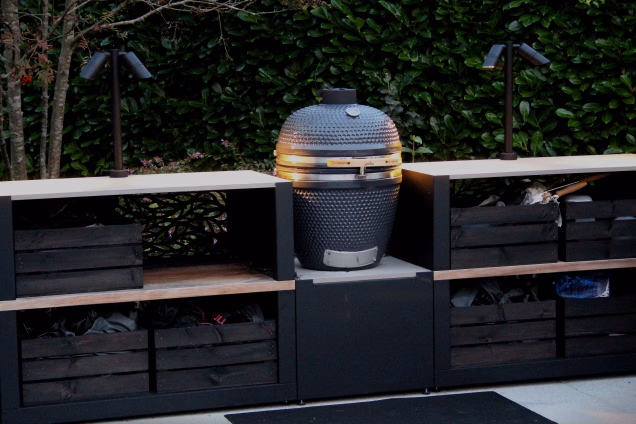 A closeup of at outdoor kitchen in Cranleigh, Surrey, at dusk, featuring a Grillo Gusto kamado BBQ