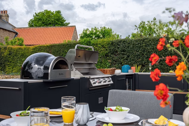 outdoor kitchen in garden with wood fired pizza oven and gas grill