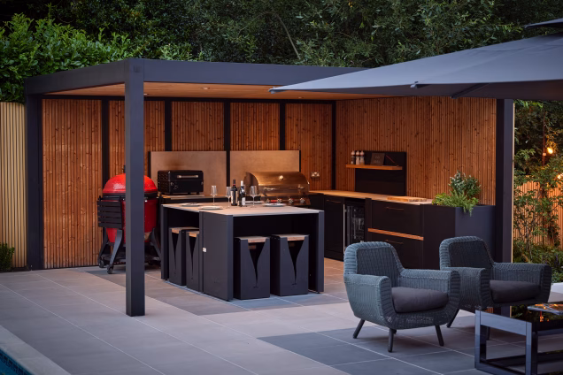 Outdoor kitchen in a side garden in Ashtead, Surrey under a wooden slat lined pergola
