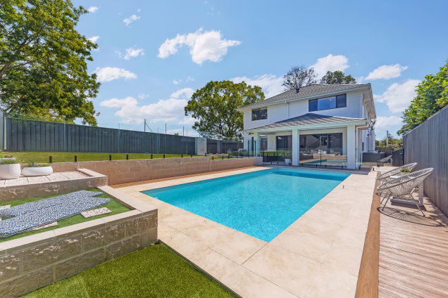 A view across the pool towards a house in Old Toongabbie, Sydney, on a sunny day