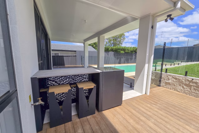 The seating of an outdoor kitchen area, showing the Habitat patterned rear fascia, in a landscaped garden in Old Toongabbie, Sydney