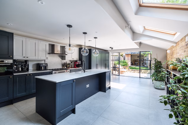 A view across the naturally-lit kitchen into the garden and outdoor living area of a beautiful house in Stoke Newington, London