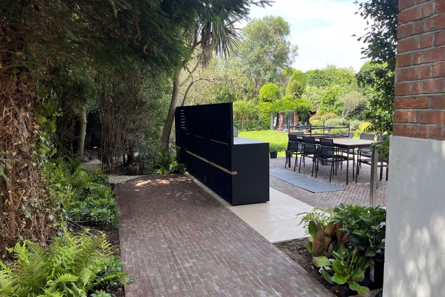 Back view of an outdoor kitchen in a subtropical style garden in Richmond, London
