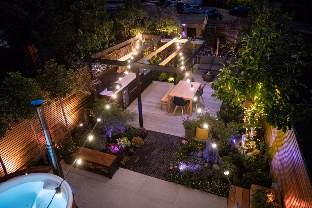 Looking down on a landscaped garden in London featuring a hot tub, outdoor kitchen and seating areas