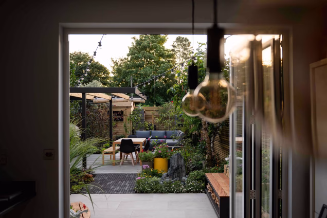 Looking out of patio doors towards a modern outdoor living garden with sofas