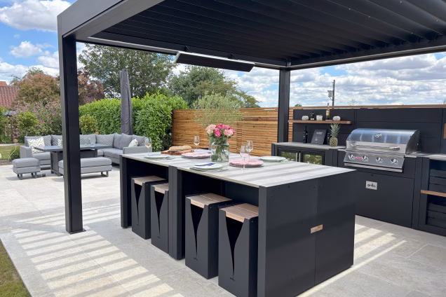A Grillo outdoor kitchen under a pergola, featuring a bar seating island with 8 Grillo Blaze bar stools