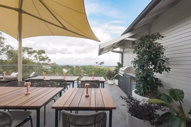 Looking across the seating and outdoor kitchen area of The Verandah at the magnificent view out to the Tasman Sea