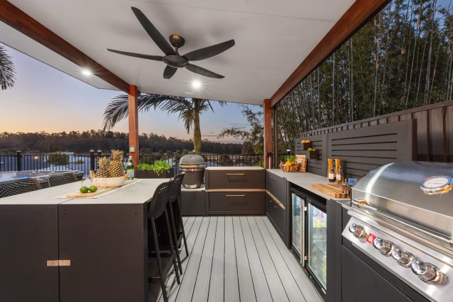 large outdoor kitchen on decking with bull gas bbq and gusto charcoal bbq and other kitchen cabinets