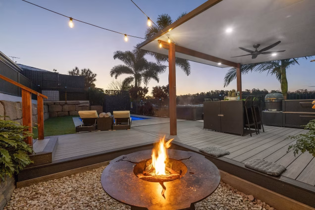 chefs anvil firepit area in garden with pool and outdoor kitchen
