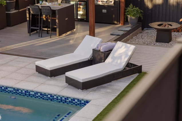 pool chairs next to pool and next to grill outdoor kitchen