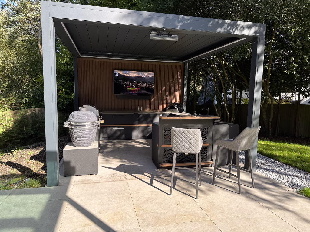 outdoor kitchen on patio under pergola on patio with seating, storage and cooking appliances