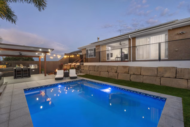 pool in garden with outdoor kitchen on decking
