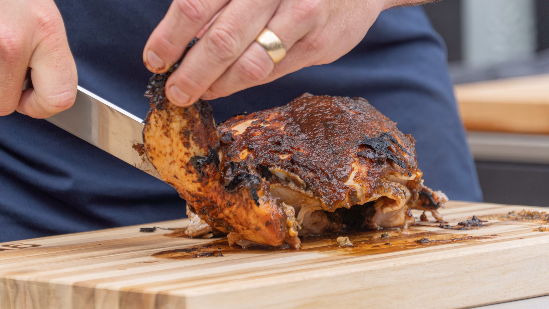 closeup of tom cutting bbq'd chicken
