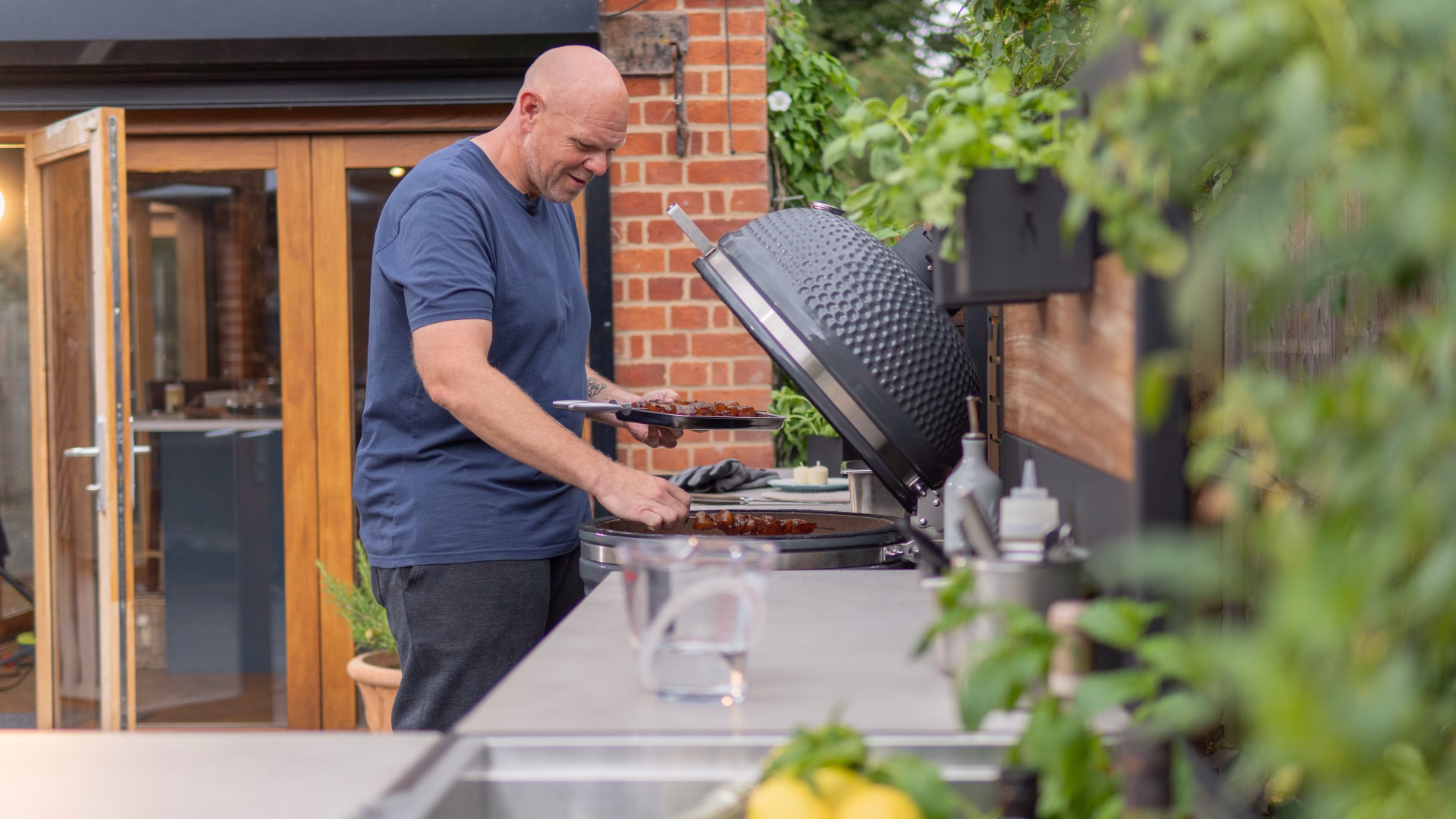 tom putting monkfish skewers on bbq