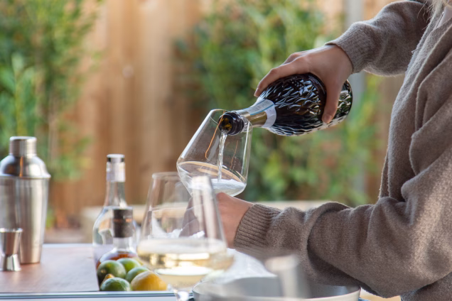 Champagne is poured into wine glasses in a Grillo kitchen