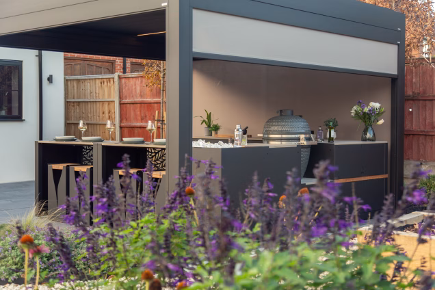 Looking through flowers at a Grillo kitchen and pergola in Acle, Norwich