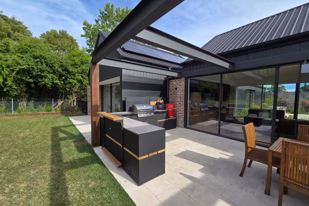 Looking along an L-shaped outdoor kitchen in Moss Vale, with large bifolding doors behind it