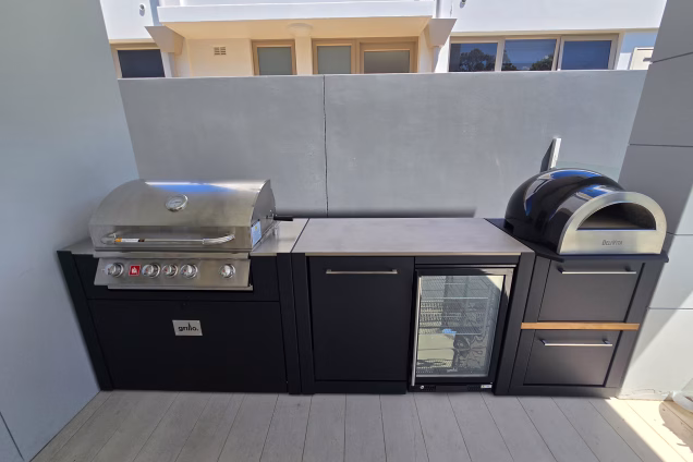 An outdoor kitchen with a powerful Bull Angus gas grill, Delivita pizza oven and an outdoor fridge in a Sydney alfresco