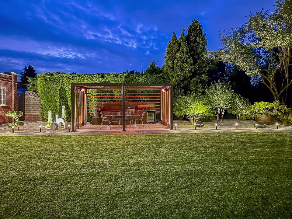Grillo outdoor kitchen on a patio set in the middle of a gravel area with water features and plants