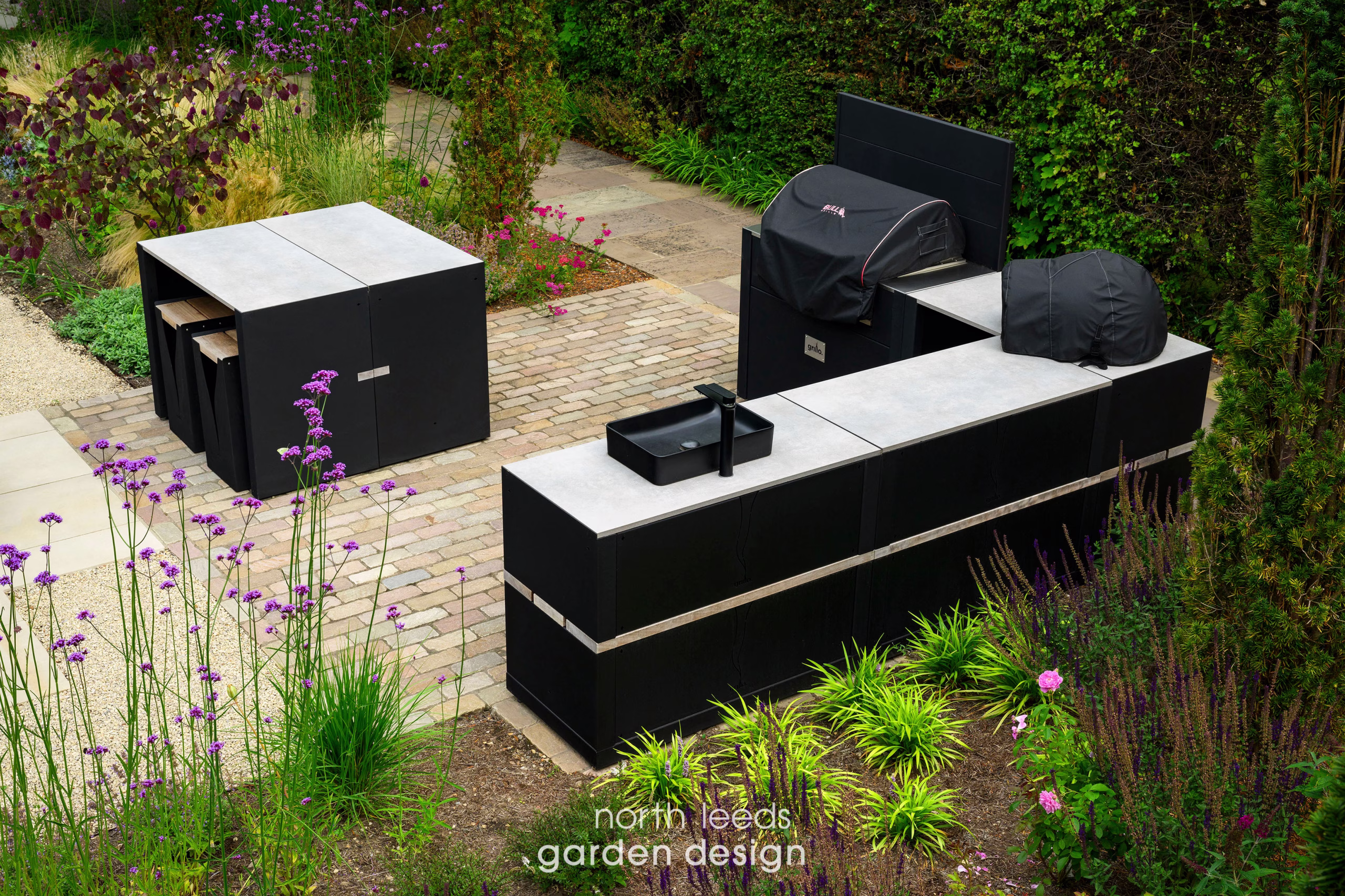 outdoor kitchen on large patio with covers over the bbqs