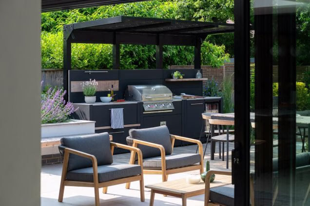 outdoor kitchen under metal covering with storage, bull gas grill station and drinks fridge and bin unit