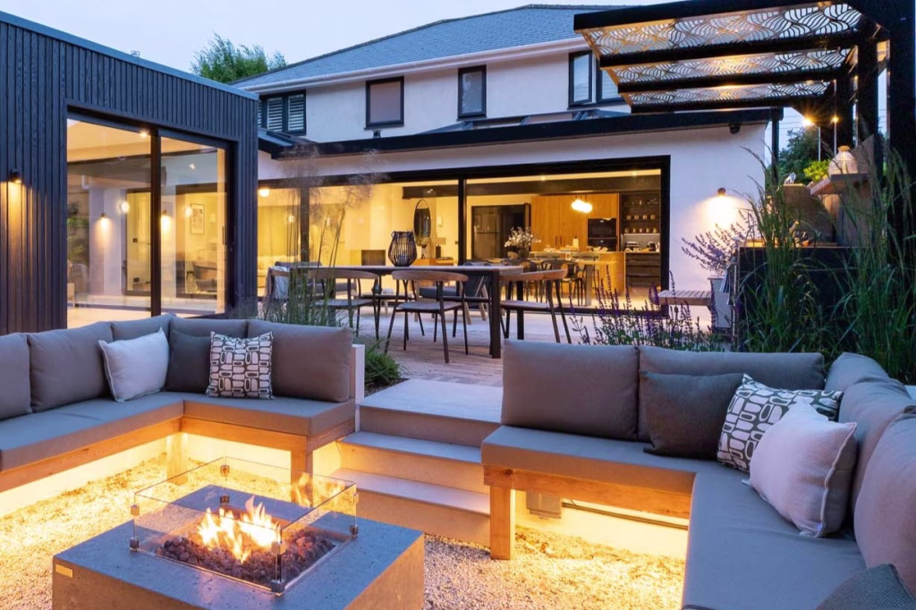 outdoor area with sunken firepit seating area, outdoor kitchen and eating area.