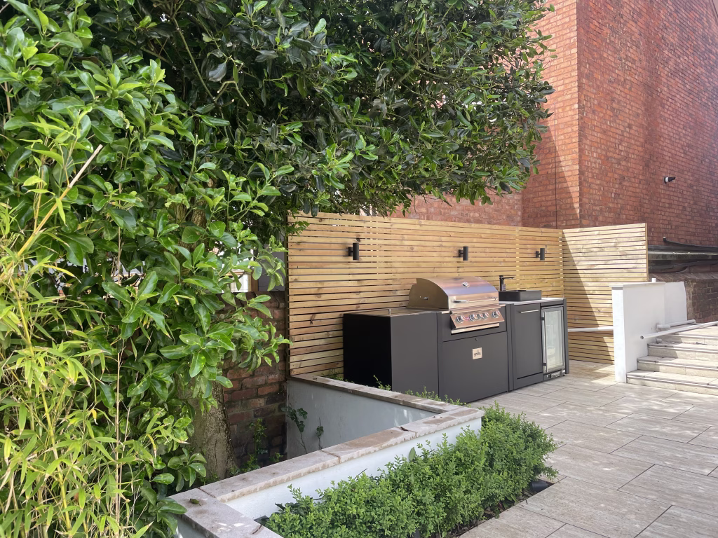 outdoor kitchen on patio in garden with bull gas grill and drinks fridge