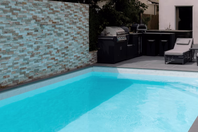 A swimming pool with a Grillo kitchen alongside