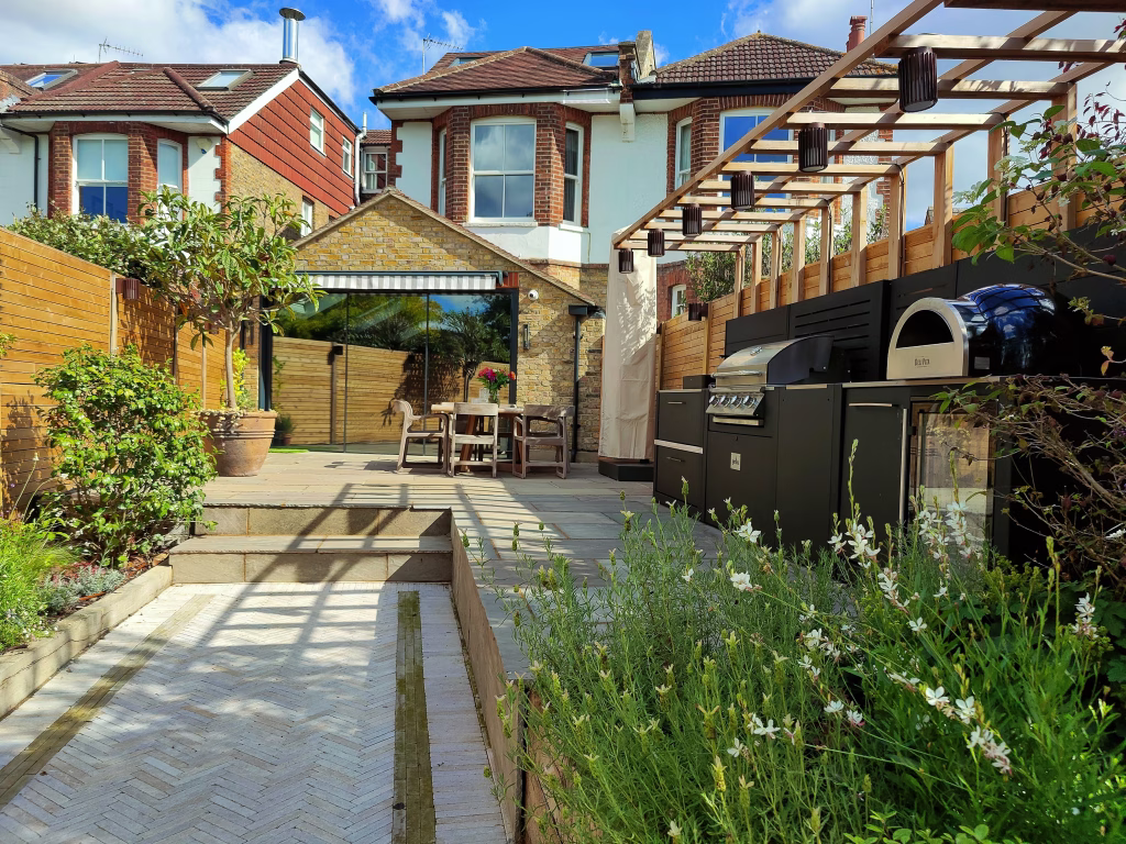 A narrow garden of a semi-detached house in Richmond, London, featuring a Grillo outdoor kitchen