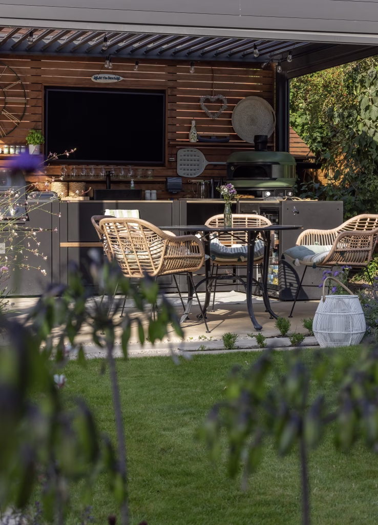 pergola with outdoor kitchen, outdoor tv and bbqs under on patio